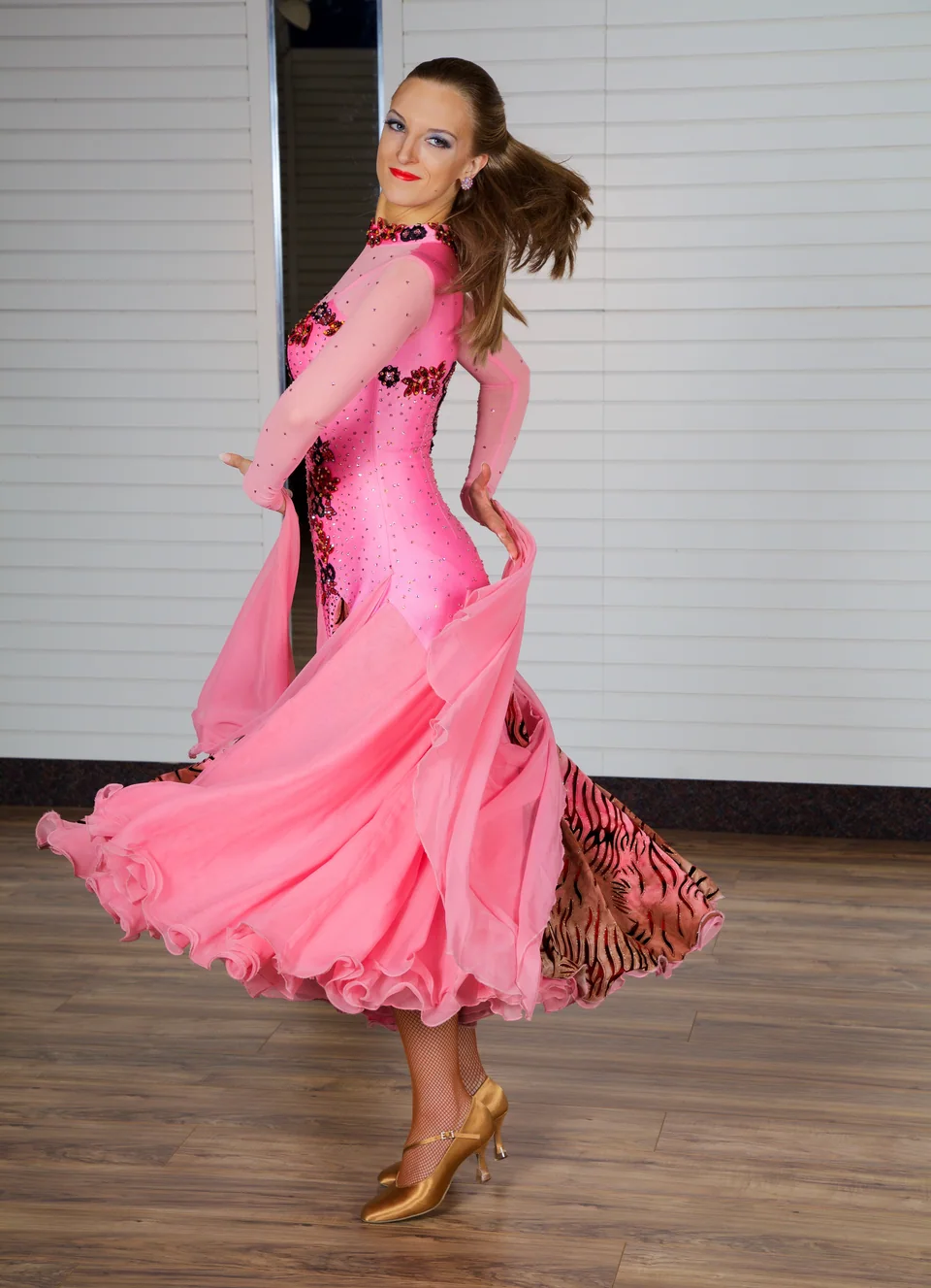 Bria dancing in a pink ballroom dress, with her full movement and shoes visible